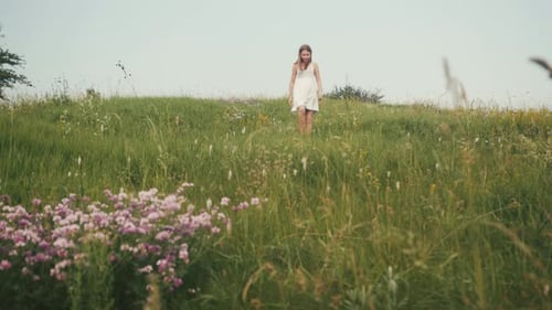 Goodlooking Teenage Girl Walking Through Field Full of Flowers Enjoying Beauty Child Raising Hands
