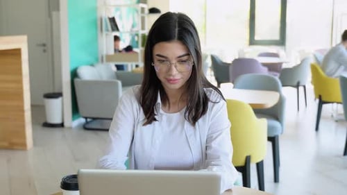 Young Woman Working on Laptop in Modern Office