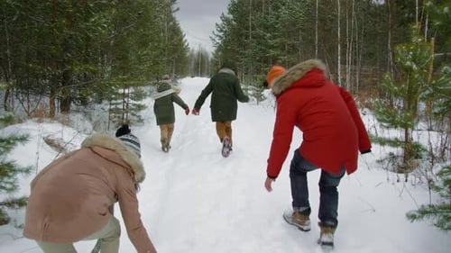 Fröhliche Eltern jagen Kinder und werfen Schneebälle beim Winterspaziergang
