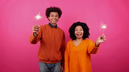 Young Adults Celebrating with Sparklers in a Pink Studio