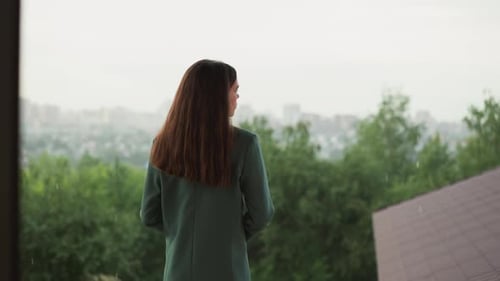 Woman Looking at Rainy View From Window