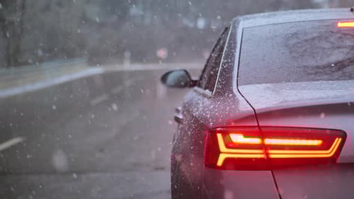 Stopping the car in the snow under the falling snow.Snowfall on the road. Car traffic in winter seas