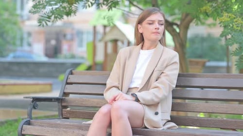 Young Woman Checking Watch on Park Bench