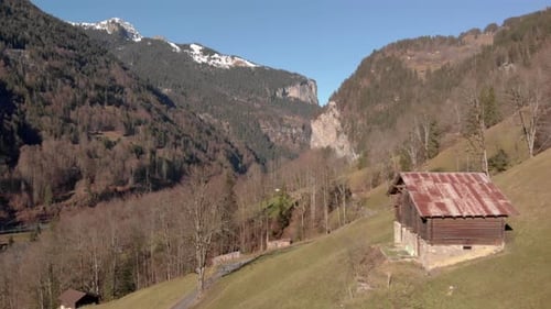 Vista aérea de uma cabana de montanha em primeiro plano e um vale pitoresco ao fundo, Lauterbrunnen