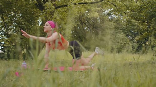 Athletic Sporty Fit Girl Doing Workout in Park on Sport Mat Performing Training Yoga Plank Pose