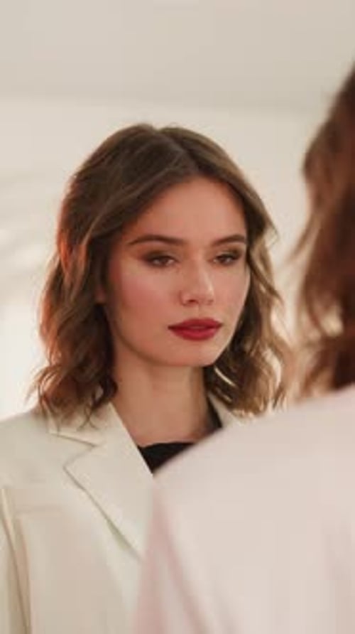 Une dame élégante au maquillage brillant aime se regarder dans le miroir