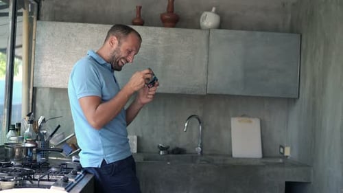 Man Using Mobile Phone in Modern Kitchen Indoors