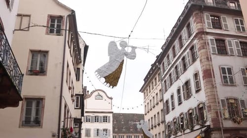 angel decoration floating above european city street near Festive Christmas market in Strasbourg, Fr