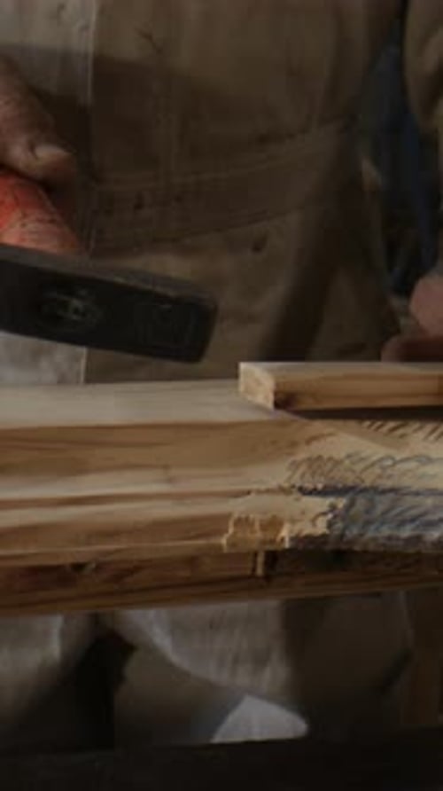 Mature Carpenter Uses Hammer Pressing Plank Into Wooden Frame