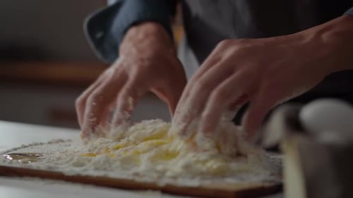 Flour, chef in action concentrated Mixing flour with egg to make dough In a specialized pasta