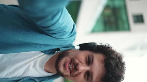 man walking down the street in headphones listening to music and taking selfie