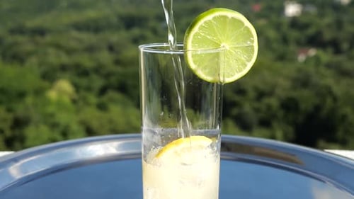 Pouring Effervescent Drink with Lemon and Lime