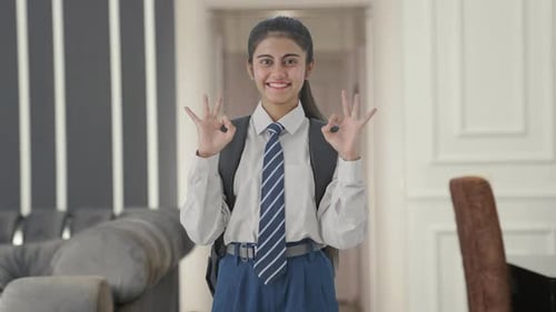 Happy Indian school girl showing okay sign