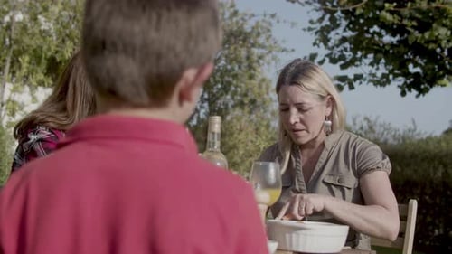 Family Eating Lunch Together in Rural Garden