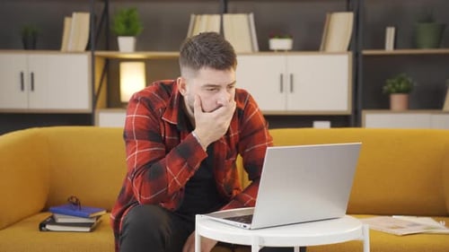 Man Using Laptop on Couch for Video Call