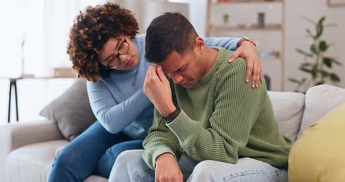 Couple, depression and woman comfort man with empathy, support and love while sitting in living room