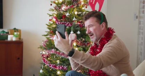 Man Smiling on Video Call Near Christmas Tree