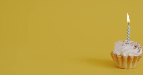 Festive Cupcake with Candle Flame on Yellow