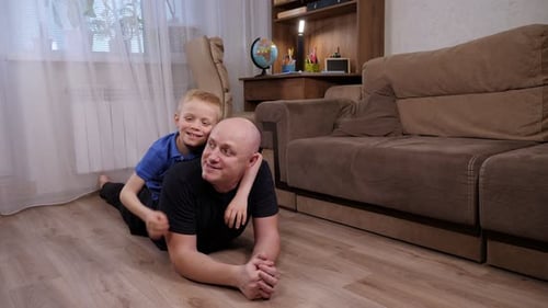 Un père heureux et son petit fils s'amusent à la maison dans le salon