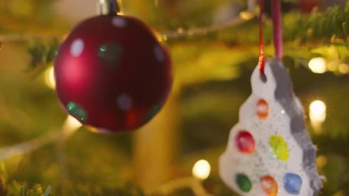 Close Up Sliding Shot of Decorated Christmas Fir Tree Bourballs and Small Hanging Ornaments