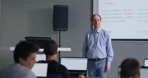 Lehrer für Informatik und Programmieren spricht im Klassenzimmer, Schüler hören ihm zu