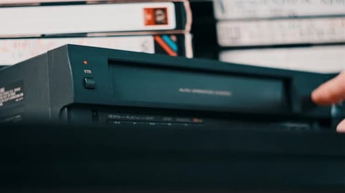 Hand Inserting VHS Tape Into VCR Player
