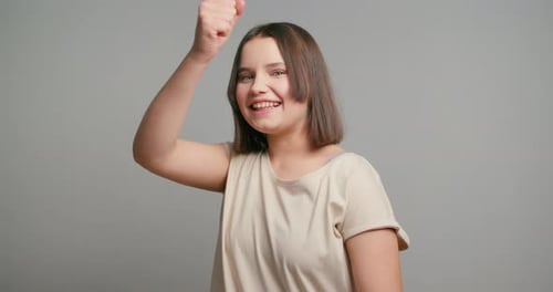 Excited Woman Cheers with Fists Raised in Air