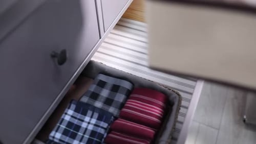 Woman taking handkerchief out of dresser indoors, above view