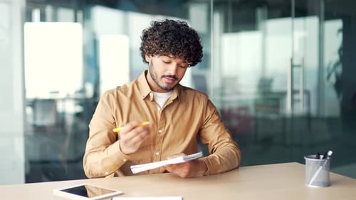 Webcam view Employee watching video call training notes in a notebook looking at the camera sitting