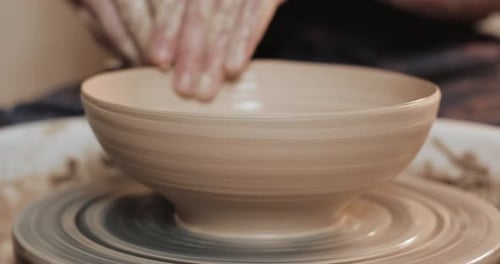 Potter in the Potter's Wheel Makes Ceramic Product Using His Hands and Pottery Tools Close Up