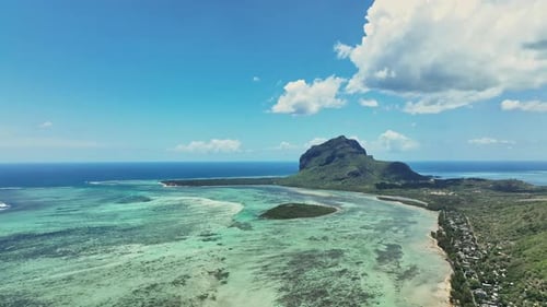 An aerial view of a tropical island with a mountain in the background