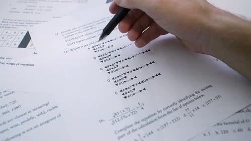 Gros plan de l'étudiant remplissant à la main une épreuve d'examen à choix multiples, remplissant les réponses sur une base standardisée