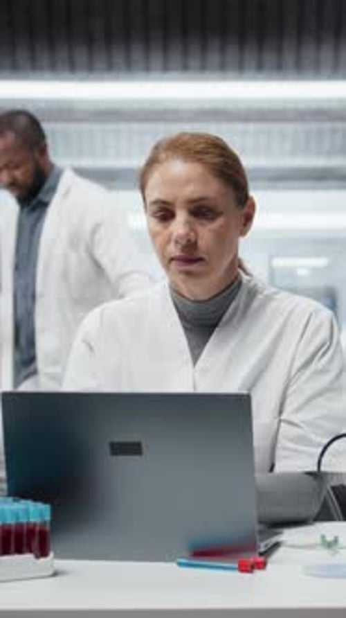 Frustrated Scientist in Lab with Laptop and Blood Samples