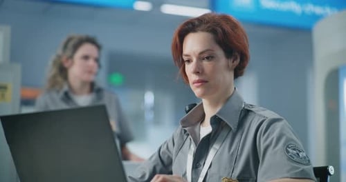 Airport Security Checkpoint Close Up of Female TSA Officer Working on Laptop