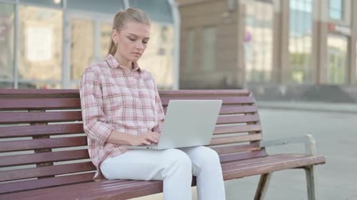 Woman Works on Laptop in Urban Park Setting