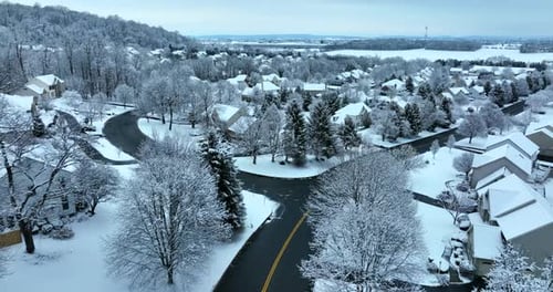 American suburbia in winter snow. Residential housing district in early morning fresh snowfall. Aeri