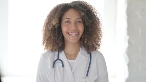 Smiling Woman Doctor in White Coat with Stethoscope