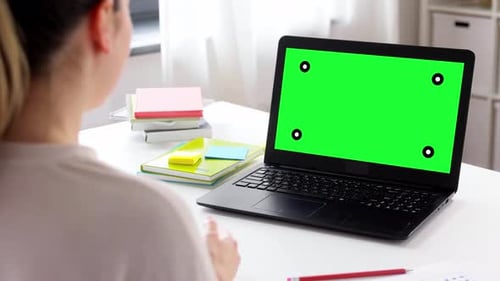 Woman on Video Call Using Laptop with Green Screen