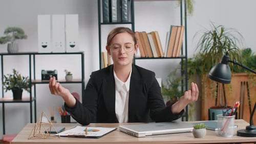 Businesswoman Working on Laptop Meditating Doing Yoga Breathing Exercise in Lotus Position at Office