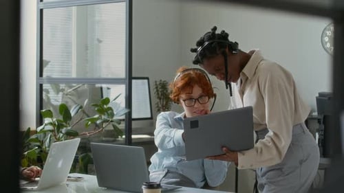 Young Women Collaborate on a Laptop in Office