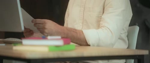 Nahaufnahme eines Mannes, der den Desktop-Computer benutzt, und während der Büroarbeitszeit Papier auf der Tastatur eingeben