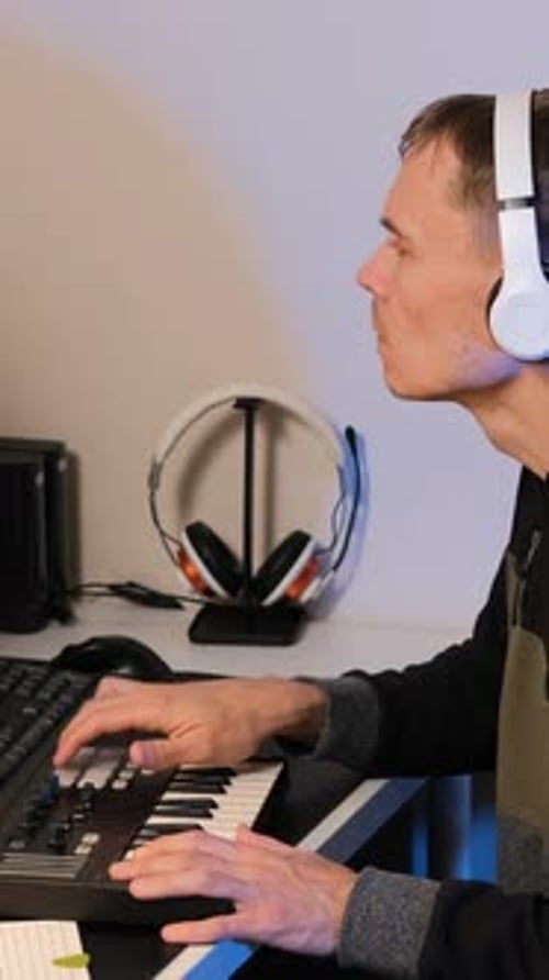 Young Adult Playing Keyboard in Home Studio