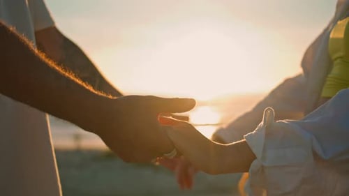 Love Couple Connecting Hands Bright Sun Beach Closeup Lights Between People