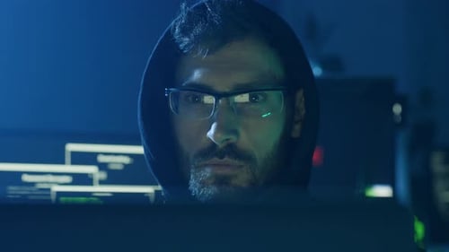 Ein fokussierter Hacker, der Daten in einer schwach beleuchteten Umgebung und Umgebung sorgfältig analysiert