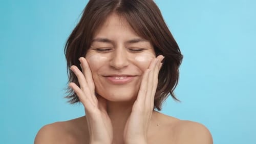 Closeup of a Beautiful Girl Applying Cream on Her Face and Massaging It