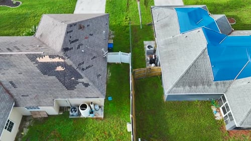 Top View of Leaking House Roof Covered with Protective Tarp Sheets Against Rain Water Leaks Until