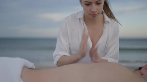 Unrecognizable Man Gets Back Massage with Oil at the Beach