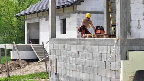 Construction Worker Working on Side of House