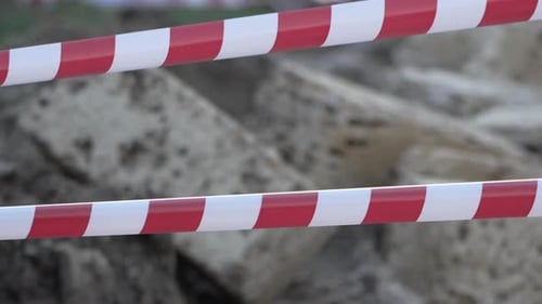 Fita de advertência vermelha e branca balançando no sinal de proteção contra o vento Não cruze a linha vermelha e branca