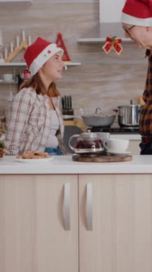 Senior Man Gives Christmas Gift to Young Woman